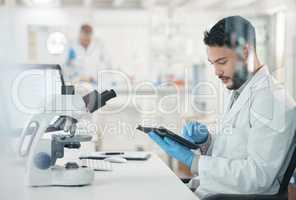 Making informed decisions based off his thorough research. a young scientist using a digital tablet while working in a lab.