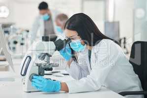 The best way forward is to keep at it. a young scientist using a microscope in a lab.