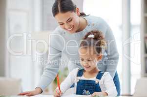 Moms here to help you. a young mother helping her daughter with her homework at home.