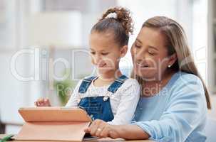 Shes never too young to teach me things. a little girl and her grandmother using a digital tablet at home.