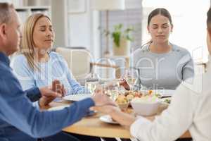 Be grateful, always. a beautiful family blessing the food with a prayer at the table together at home.