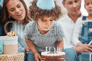 Big boys blow out all their candles. an adorable little boy celebrating a birthday with his family at home.