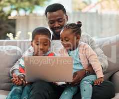 Spending time with family makes it all worth it. a young father using a laptop with his children at home.