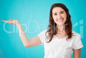 Its my top recommendation. Studio portrait of an attractive young woman posing with her hand out against a blue background.