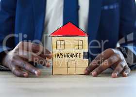 Protect your home for peace of mind. an unrecognisable businessman assembling a building with the word insurance on it.