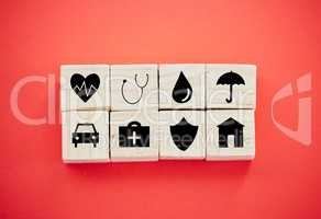 You cant predict tomorrow, but you can protect it. wooden blocks with insurance related symbols on them against a red background.