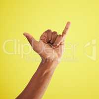 See you soon. Studio shot of an unrecognisable man showing a shaka hand sign against a yellow background.