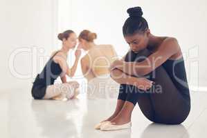 Courage is fire, and bullying is smoke. a ballet dancer sitting away from the crowd looking nervous and stressed.