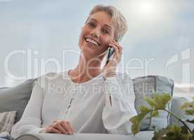 Its so good to hear from you. an attractive senior woman making a phonecall while relaxing in her living room at home.