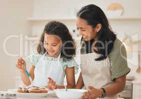 I hope the icing isnt too sweet. a mother and daughter frosting freshly baked cupcakes.