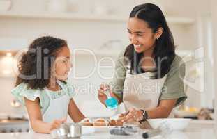 Practicing our art together. a mother and daughter frosting freshly baked cupcakes.