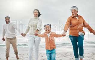 Theyre in a rush for fun. an adorable little girl pulling her parents and grandmother along the beach.