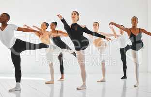 Immerse yourself in every movement. a group of young ballet dancers practicing their routine in a dance studio.