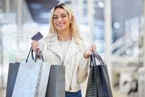 Its been far too long. a young woman holding the bank card used to make payments while shopping.