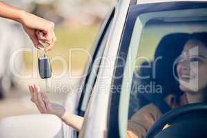 Better buckle up, buttercup. a person handing a woman the keys to her new car outside.