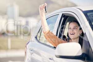 Never drive faster than your guardian angel can fly. a woman holding the keys to her new car outside.