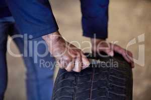 Fixing a puncture. an unrecognizable male mechanic fixing a puncture while working in his garage.