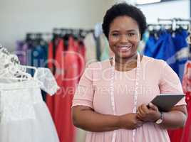 In need of some tailoring. Cropped portrait of an attractive young seamstress standing with a tablet in her boutique.