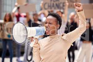Fighting for the rights of others. a young woman shouting through a loudhailer at a protest.