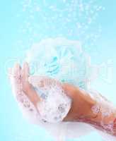 Morning showers give you just the burst of energy you need to start your day. a woman using a mesh bath sponge to wash herself.