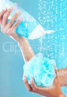 It smells amazing. an unrecognisable woman squeezing shower gel onto a mesh sponge.