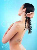 Taking a sower can make you feel like a new person. a young woman enjoying a shower against a blue background.