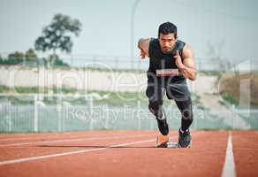 Hes got a need for speed. Full length shot of a handsome young male athlete running on an outdoor track.