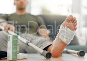 Write your injuries in dust, your benefits in marble. a unrecognizable man relaxing his foot on a table at home.