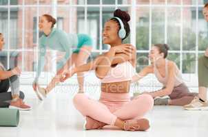 Now this is something youd want to be a part of. a young woman wearing headphones while stretching.