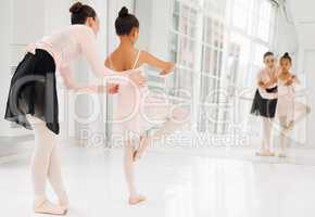 Lift those knees. a little girl practicing ballet with her teacher in a dance studio.