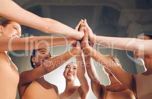 Dance lives on. a group of ballet dancers giving each other high fives.