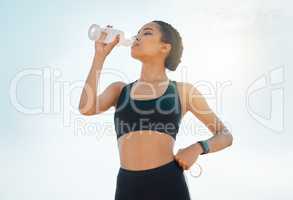 Water breaks are a necessity. a young woman re hydrating during a workout.