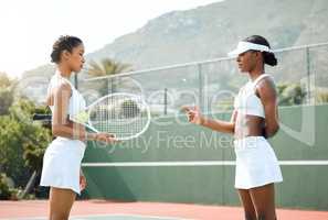 What will the outcome be. two sporty young women flipping a coin before a tennis match.