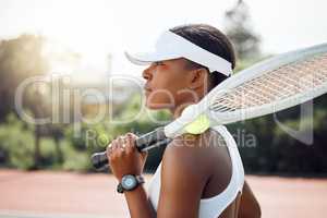 Ready to face her opponent. a sporty young woman playing tennis on a court.