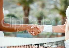 May the best player win. two sporty women shaking hands while playing tennis together on a court.