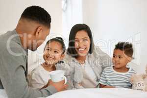 I think youre a little too young for coffee darling. a beautiful young family talking and bonding in bed together.