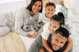 Dont let your weekend be your weak end. Portrait of a beautiful young family talking and bonding in bed together.