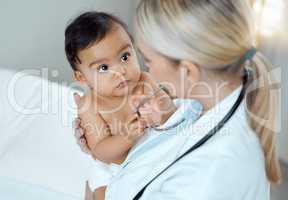 Regular checkups are vital for your childs health, development and wellness. a paediatrician examining a baby in a clinic.