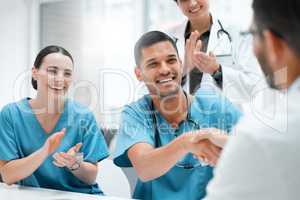 Visions become a reality when you believe. a young male doctor shaking hands with a colleague at work.