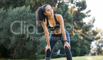 You have to do whatever it takes. a sporty young woman catching her breath while exercising outdoors.