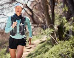 Hiking is a great way to build up your endurance. a young woman running along a trail on the mountain.