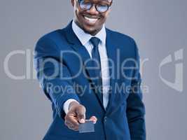 Put it on my tab. a handsome young businessman holding out his credit card in studio against a grey background.