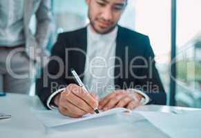 Action breeds confidence and courage. a young businessman signing a contract in a office.