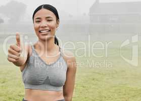 I approve. Cropped portrait of an attractive young female athlete giving thumbs up towards the camera while exercising outside.