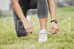 Keep it tight. an unrecognizable young female athlete tying her laces while exercising outside.