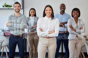 Were only one call away. Portrait of a group of businesspeople standing together with folded arms in a modern office.