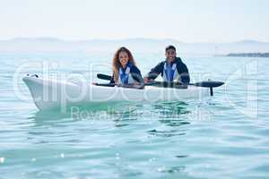 Laidback and enjoying themselves out on the lake. Portrait of a young couple kayaking together at a lake.