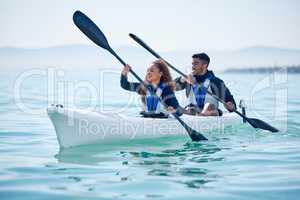 Enjoying their date out on the lake. a young couple kayaking together at a lake.