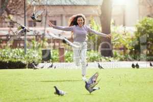 Embrace the freedom. a young woman chasing birds at a park.