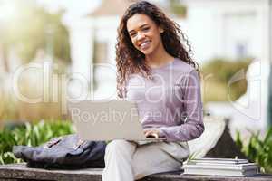 Trying to reach these deadlines. a young woman using a laptop in the park.